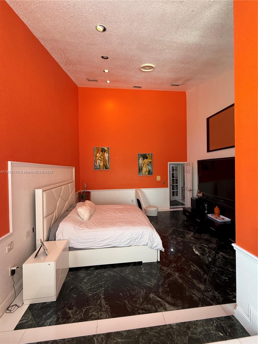 747 West 78th Street Hialeah, FL 33014 - Photo 16 of 38 a spacious bedroom with a bed and a television