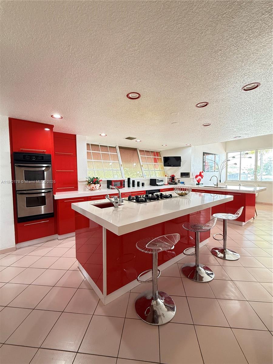 747 West 78th Street Hialeah, FL 33014 - Photo 7 of 38 a kitchen with stainless steel appliances kitchen island granite countertop a sink and cabinets