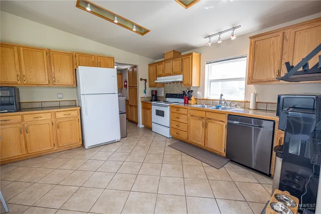 a kitchen with a sink a refrigerator and cabinets