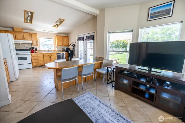 a living room with furniture a flat screen tv and floor to ceiling window