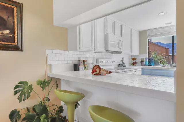a kitchen with stainless steel appliances a sink a window and cabinets