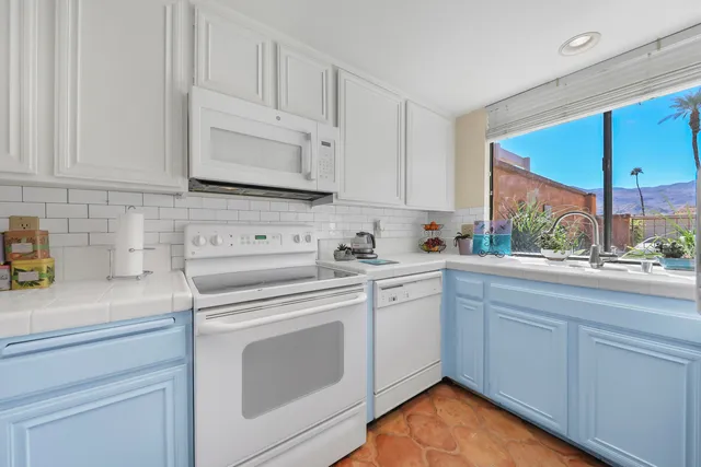 a kitchen with white cabinets appliances and a sink