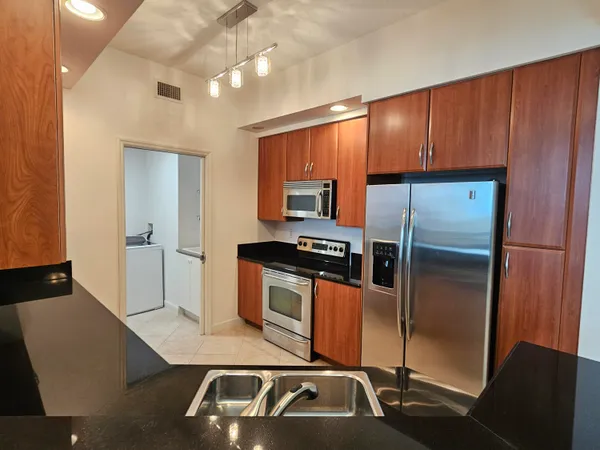 a kitchen with kitchen island a counter top space a sink and stainless steel appliances