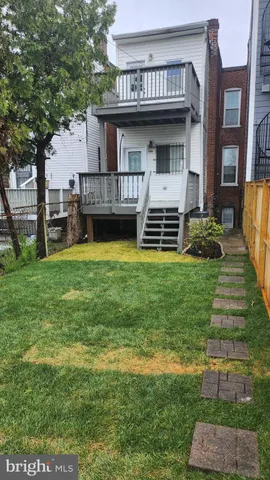 a view of a house with a big yard and large trees