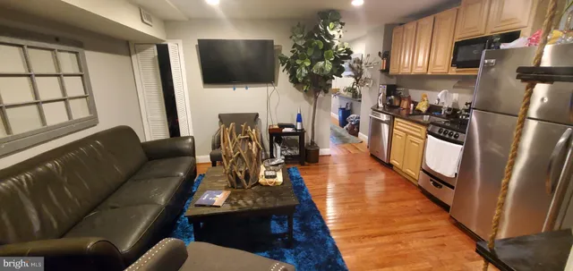 a living room with furniture a flat screen tv and a floor to kitchen