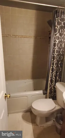 a white toilet sitting next to a bath tub