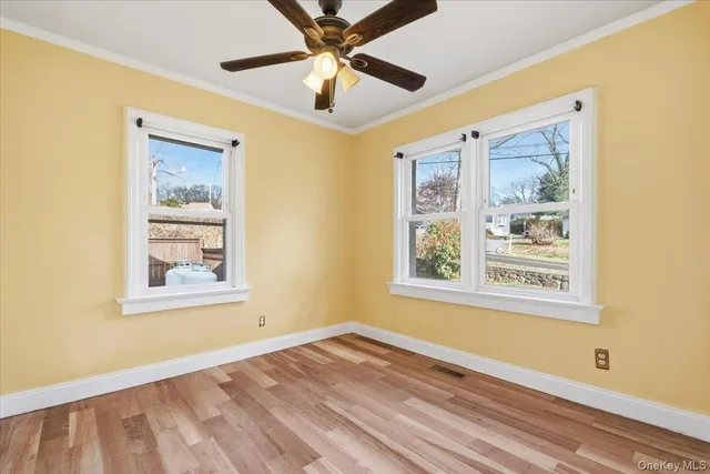 a view of an empty room with a window and a ceiling fan