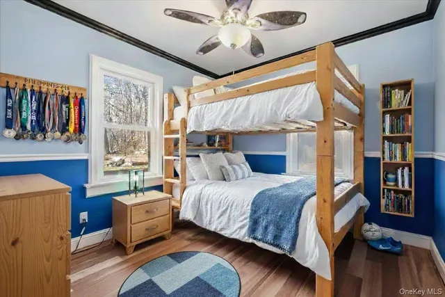a bedroom with a bed wooden floor and book shelf