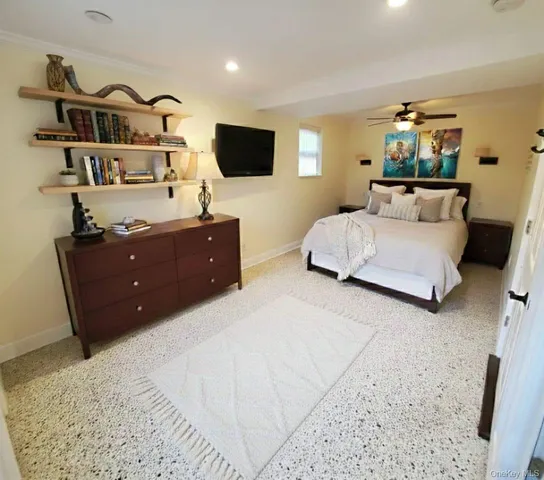 a bedroom with a bed and dresser with mirror