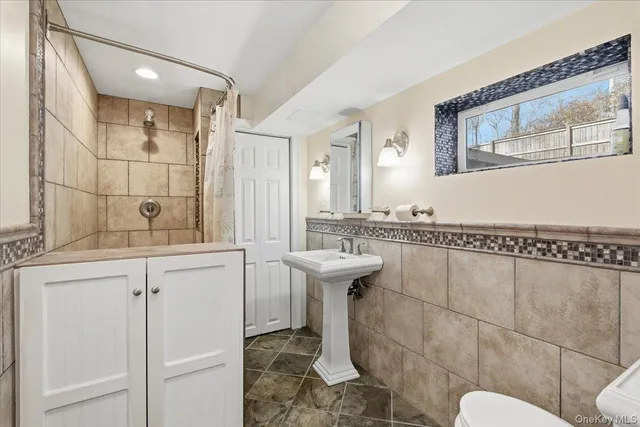 a bathroom with a sink a toilet and mirror