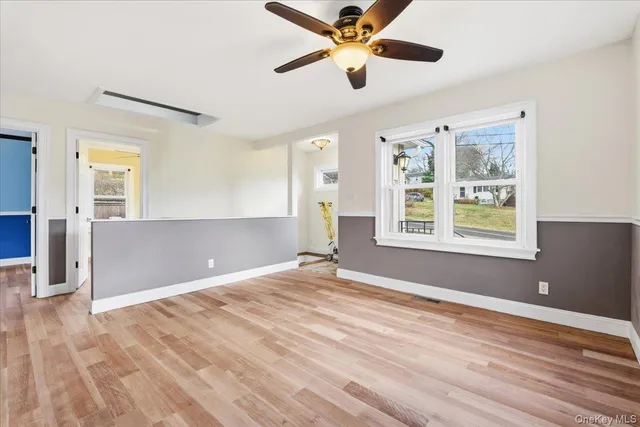 a view of an empty room with window and wooden floor
