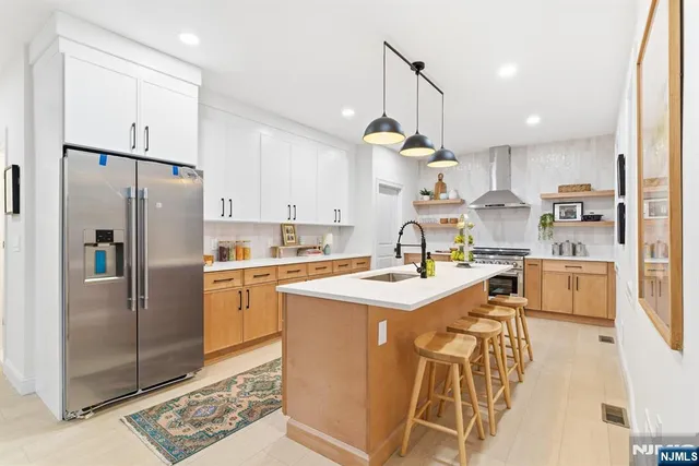 a kitchen with stainless steel appliances kitchen island a refrigerator and a sink