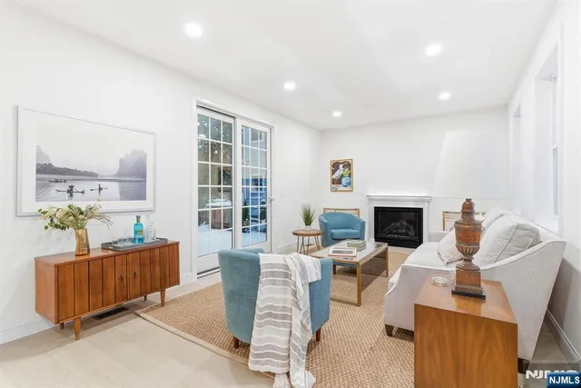 a living room with furniture a fireplace and a floor to ceiling window