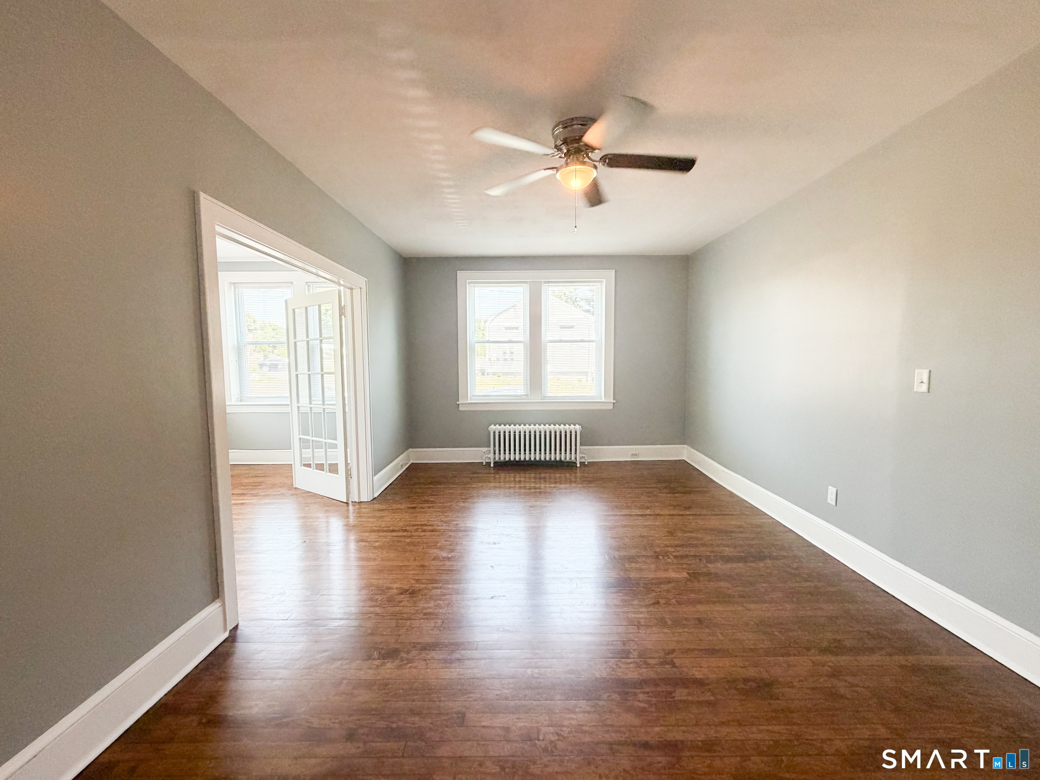 793 Milford Point Road, Unit 1 Milford, CT 06460 - Photo 5 of 16 an empty room with wooden floor and windows