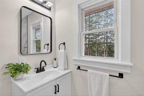 a bathroom with a sink a mirror and a window