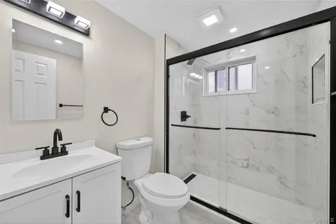 a bathroom with a sink a toilet and shower