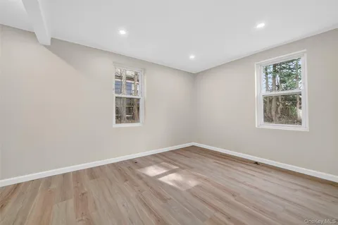 a view of a big room with wooden floor and windows