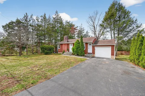 a view of a house with backyard and trees