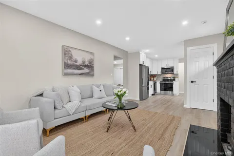 a living room with furniture and a view of kitchen