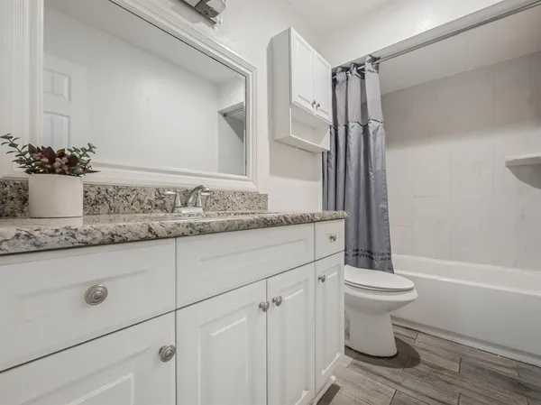 a bathroom with a granite countertop sink toilet and shower
