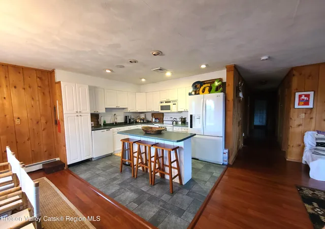 a open kitchen with stainless steel appliances granite countertop a refrigerator dining table and chairs