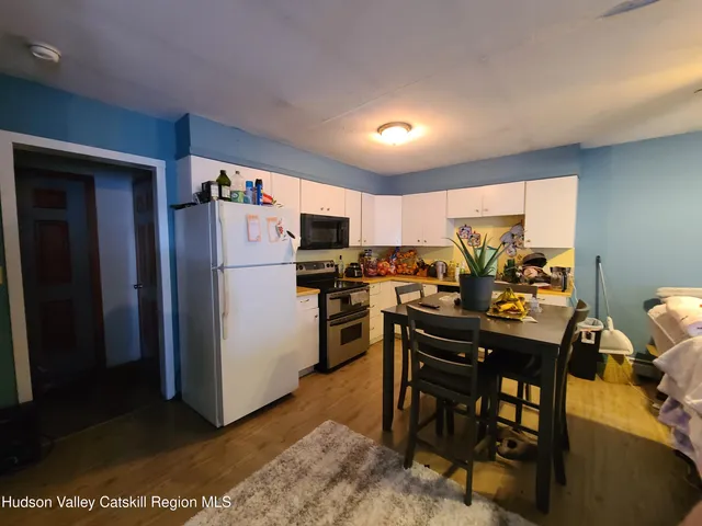 a kitchen with a refrigerator a table and chairs in it