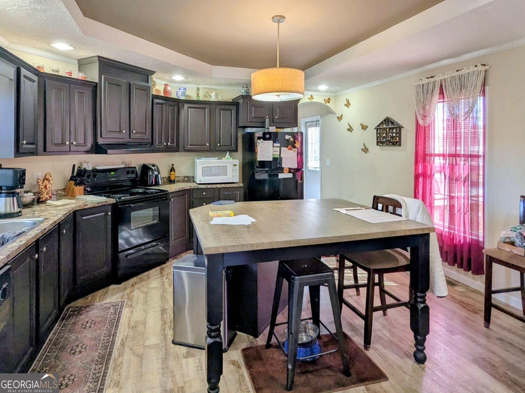 1282 Ga Highway Lyons, GA 30436 - Photo 11 of 21 a kitchen with granite countertop a stove a sink dishwasher a dining table and chairs with wooden floor