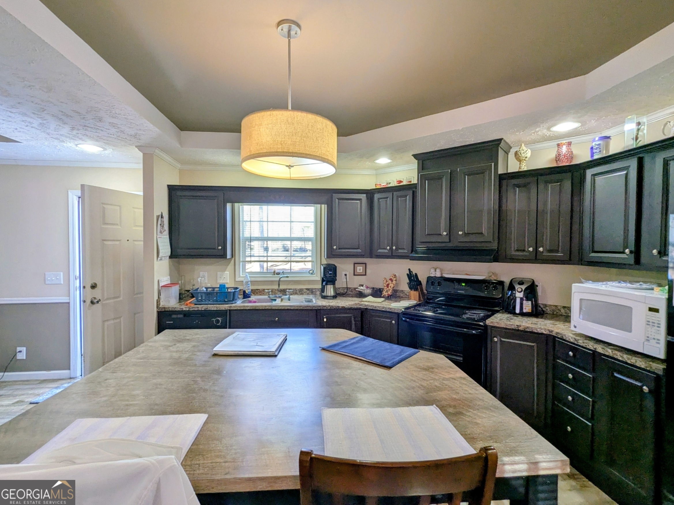 1282 Ga Highway Lyons, GA 30436 - Photo 10 of 21 a kitchen with kitchen island granite countertop a stove a sink a refrigerator dining table and chairs