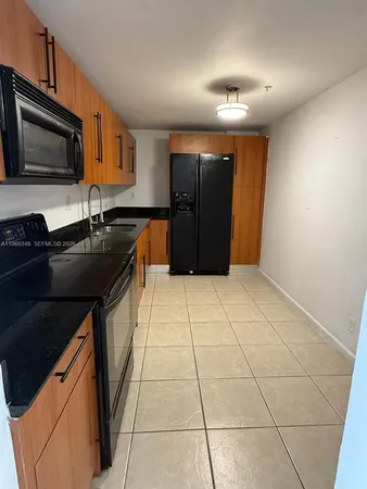 a kitchen with a sink a stove and black cabinets