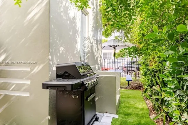 a view of a chair and table in the back yard of the house