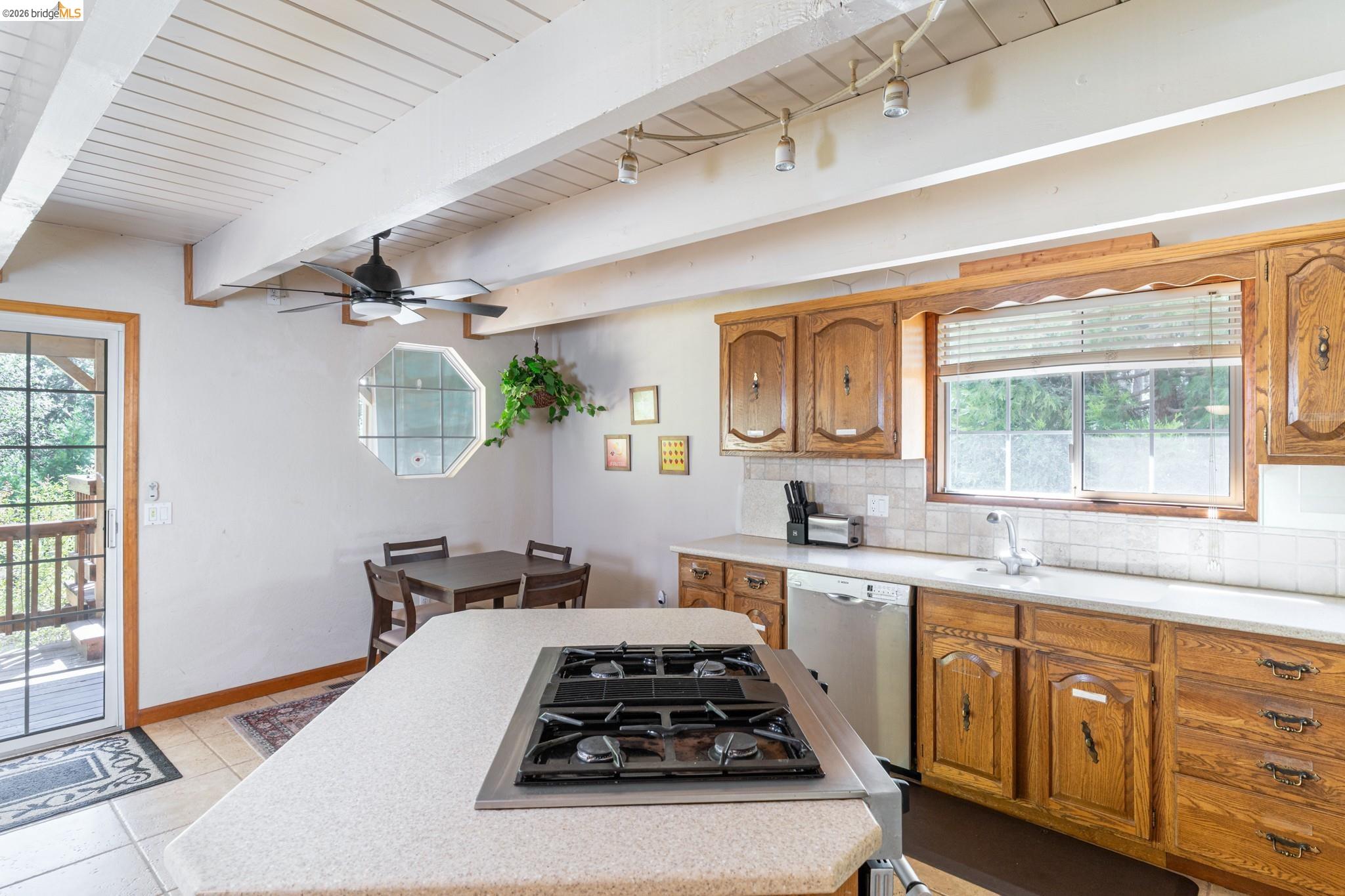 19390 Ferretti Road Groveland, CA 95321 - Photo 16 of 38 Kitchen featuring a built-in cooktop, wood cabinetry, tile flooring, and a beamed ceiling