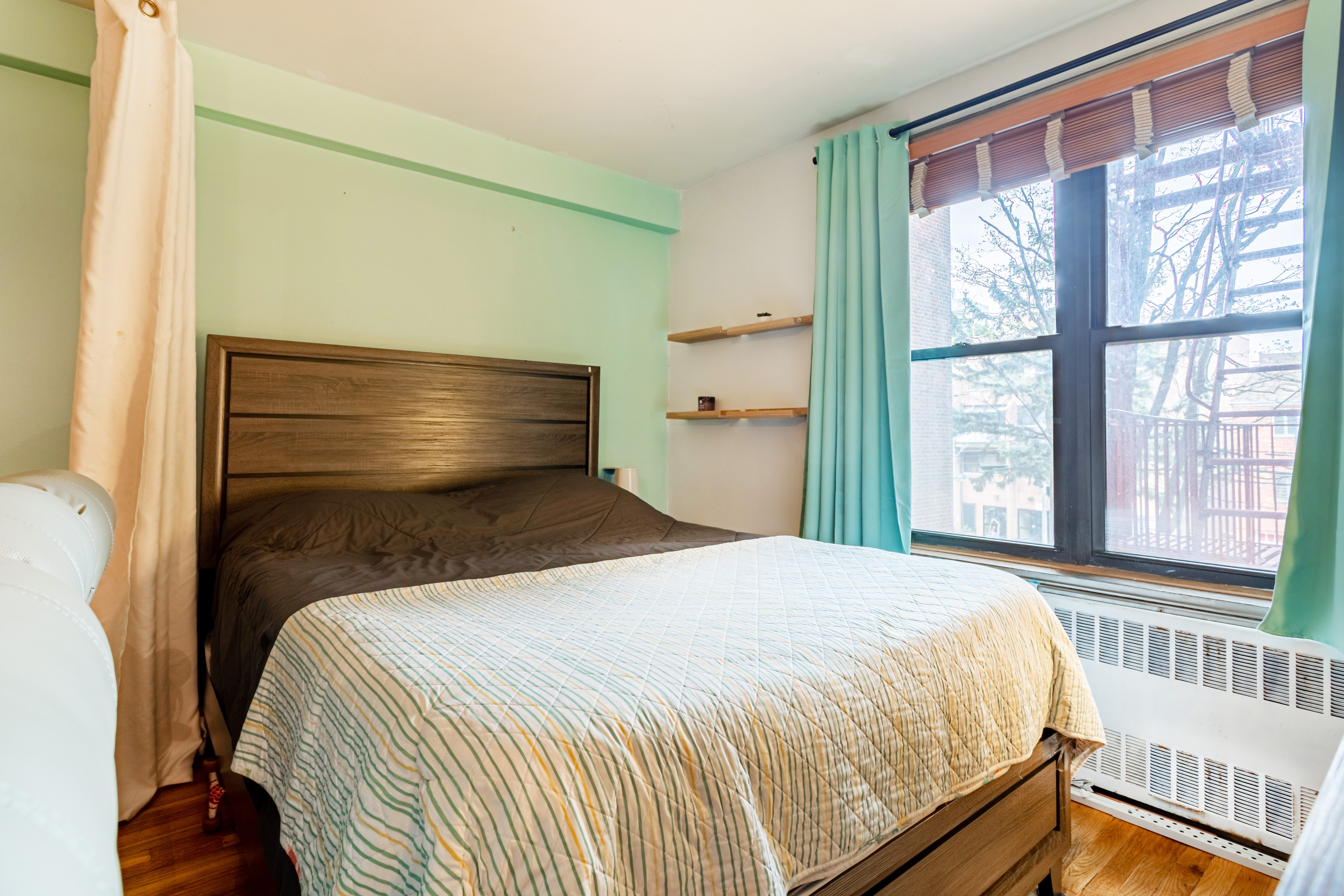 65-15 38th Avenue, Unit 2A Queens, NY 11377 - Photo 6 of 16 a bedroom with a bed and wooden floor