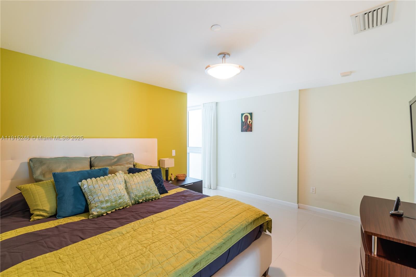 2950 Northeast 188th Street, Unit 504 Aventura, FL 33180 - Photo 20 of 33 a bed sitting in a bedroom next to a window