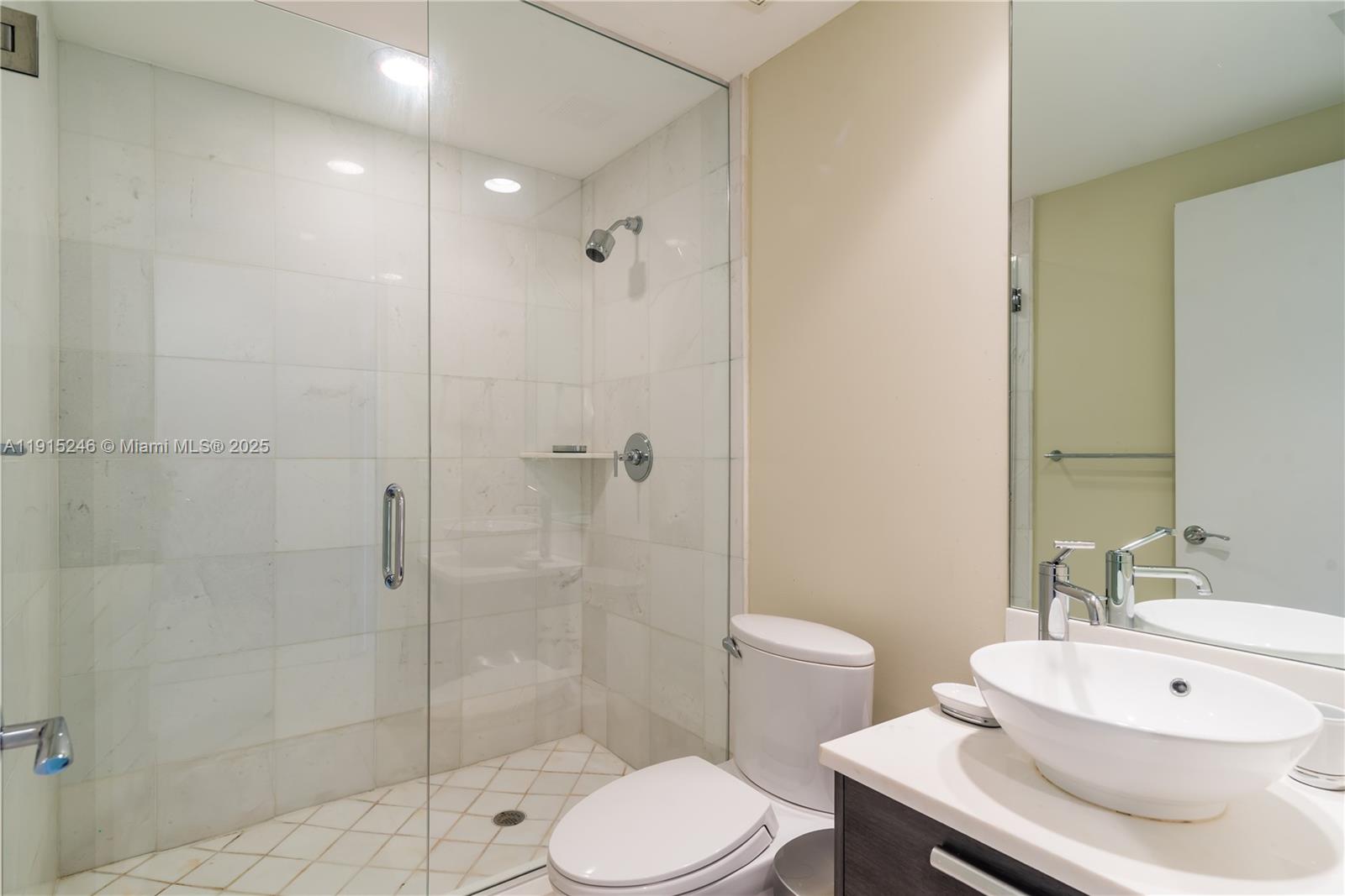 2950 Northeast 188th Street, Unit 504 Aventura, FL 33180 - Photo 23 of 33 a bathroom with a sink toilet a mirror and shower
