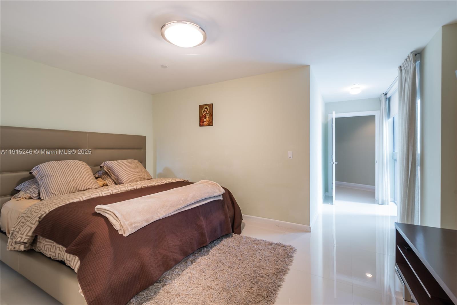 2950 Northeast 188th Street, Unit 504 Aventura, FL 33180 - Photo 27 of 33 a bedroom with a bed and lamp