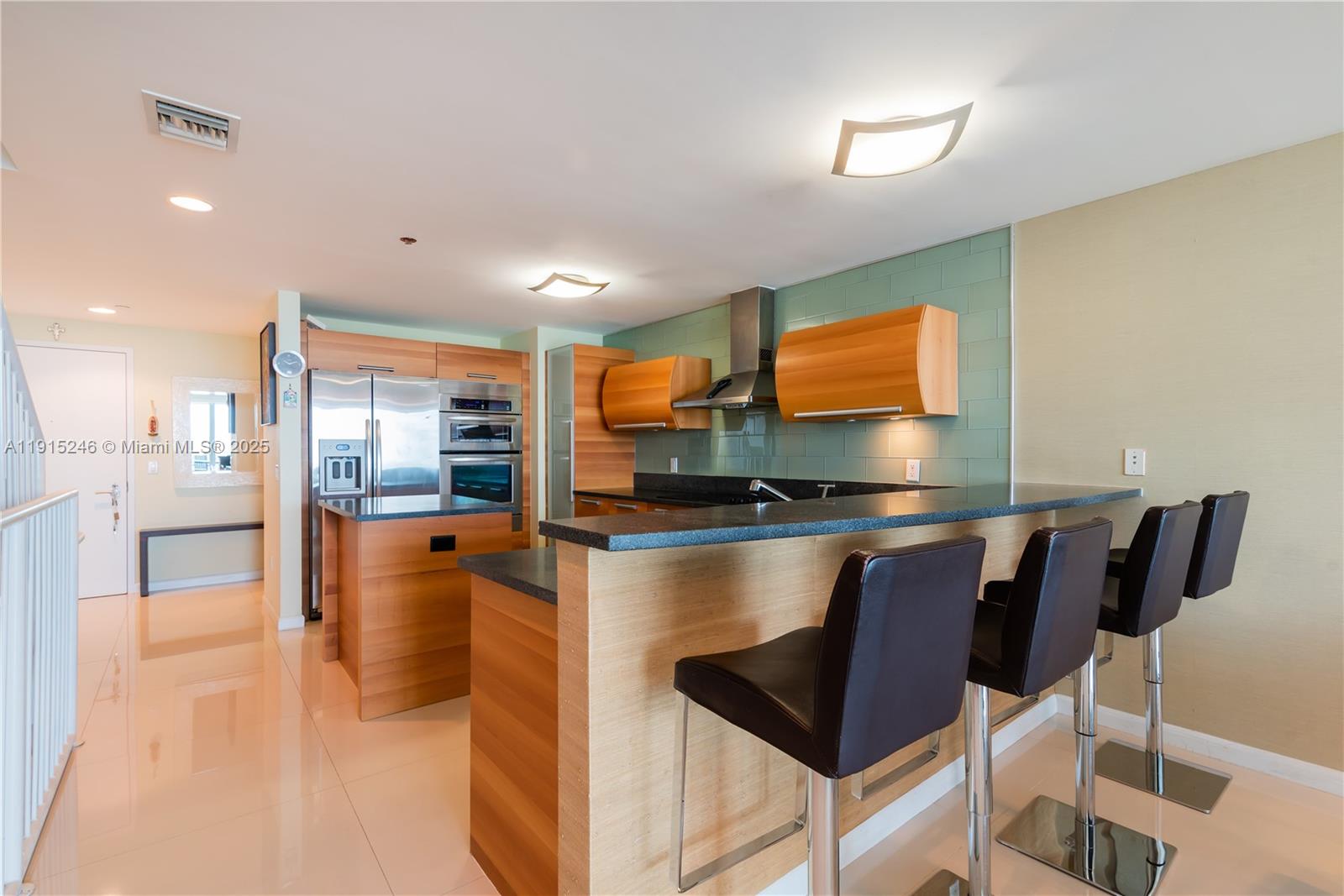 2950 Northeast 188th Street, Unit 504 Aventura, FL 33180 - Photo 3 of 33 a kitchen with stainless steel appliances granite countertop a sink and a refrigerator