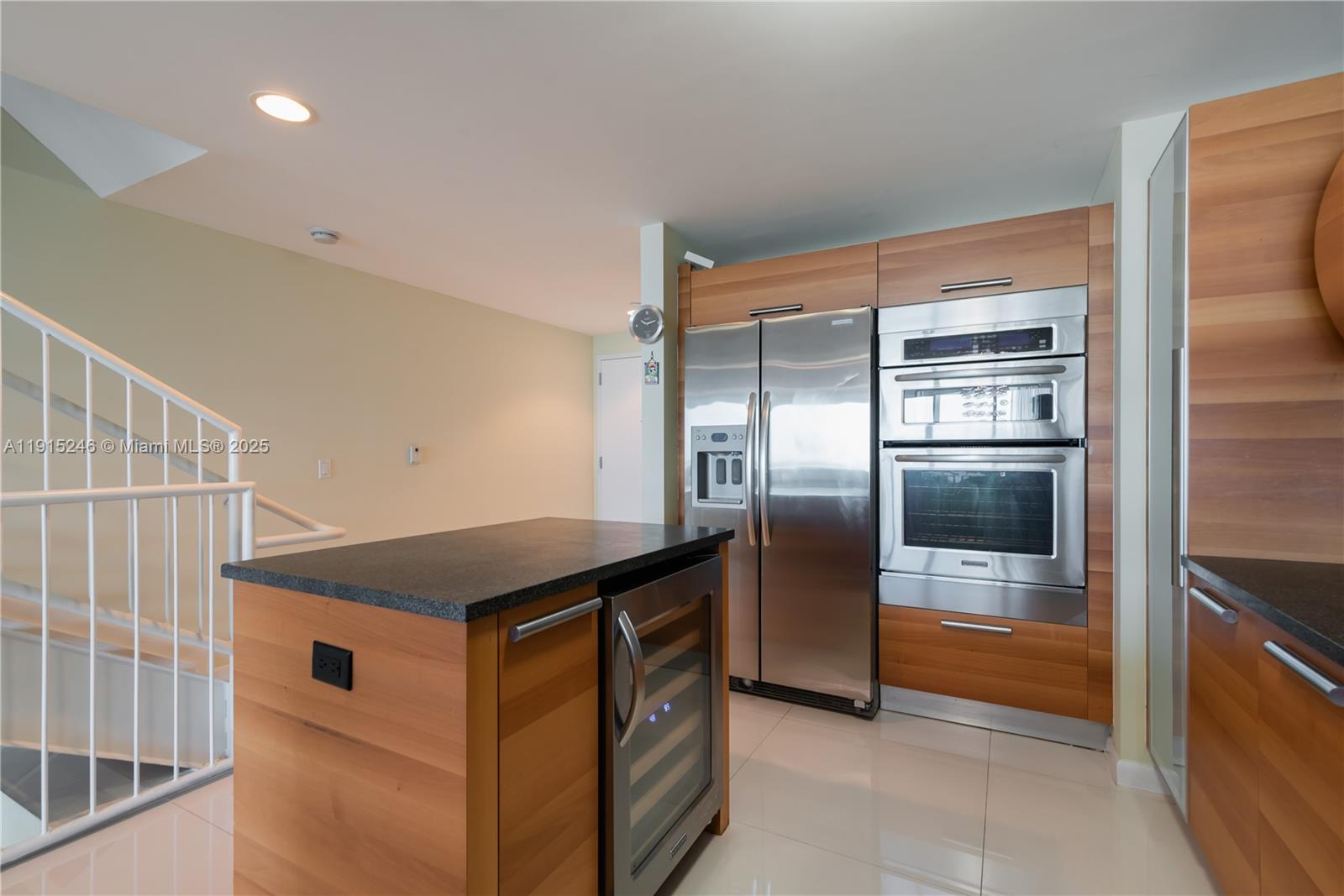 2950 Northeast 188th Street, Unit 504 Aventura, FL 33180 - Photo 7 of 33 a kitchen with stainless steel appliances kitchen island granite countertop a refrigerator and a sink