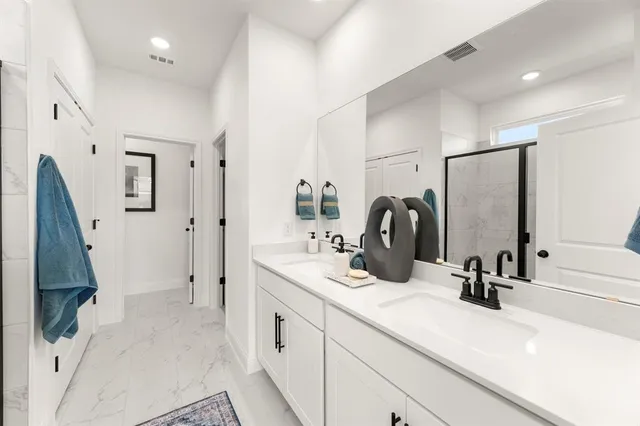 a bathroom with double vanity sink and a mirror