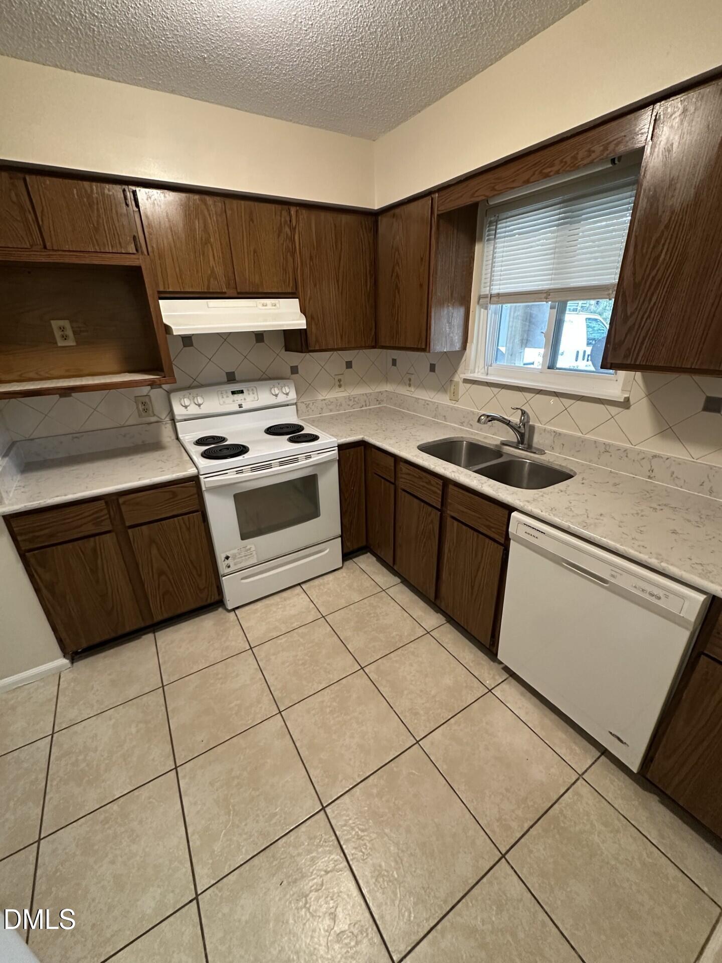 4912 North New Hope Road Raleigh, NC 27616 - Photo 2 of 14 a kitchen with stainless steel appliances granite countertop a stove a sink and a refrigerator