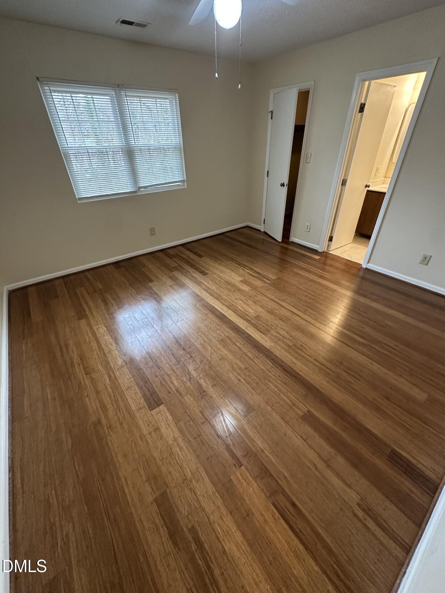 4912 North New Hope Road Raleigh, NC 27616 - Photo 9 of 14 an empty room with wooden floor staircase and windows