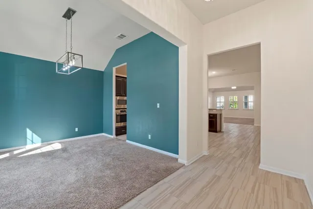 a view of a room with wooden floor kitchen and windows