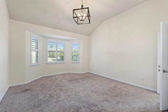 an empty room with windows and ceiling fan