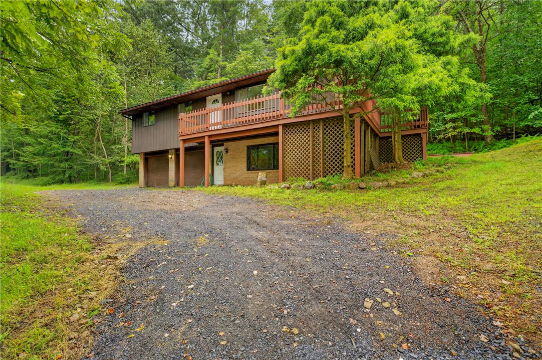 1570 Astolat Road Effort, PA 18330 - Photo 3 of 48 Mature trees surround this rustic multi-level home featuring an expansive upper balcony and integrated garage.