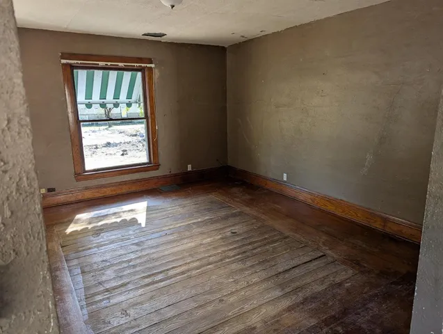 wooden floor in an empty room with a window
