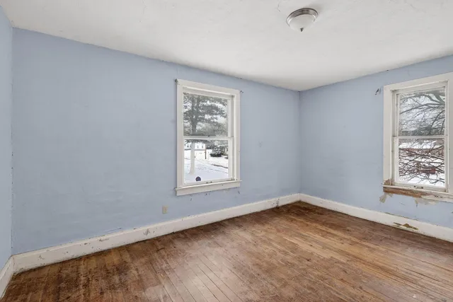 a view of a room with wooden floor and a window