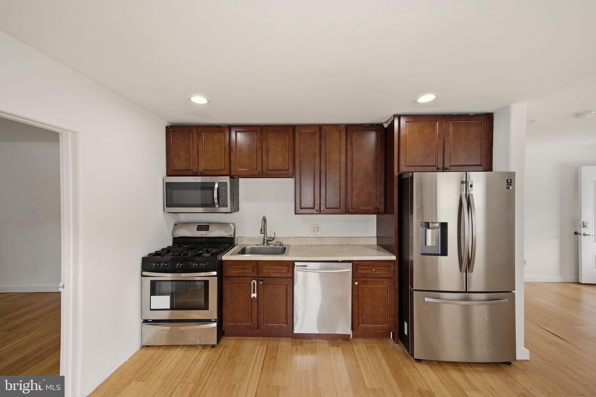 1812 Kitty Hawk Road Essex, MD 21221 - Photo 12 of 44 a kitchen with stainless steel appliances a refrigerator stove and sink