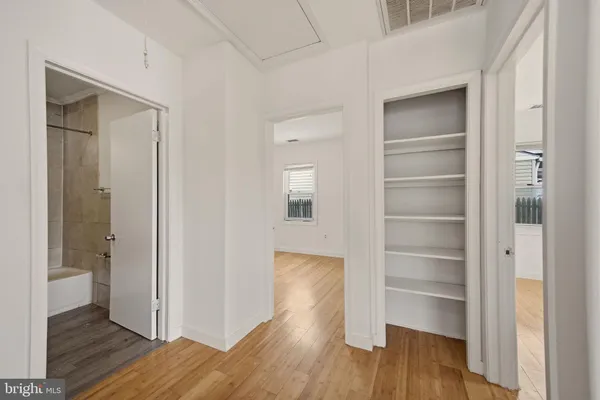 a view of walk in closet with wooden floor