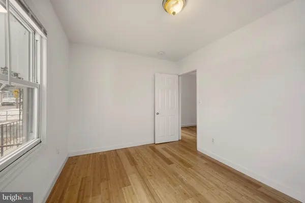 a view of a room with wooden floor and a window