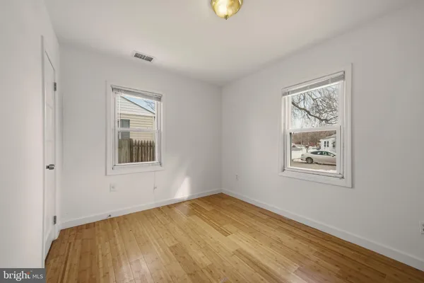 a view of an empty room with a window and closet area
