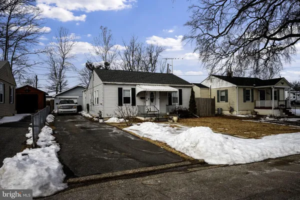 a view of a house with snow on the side of road